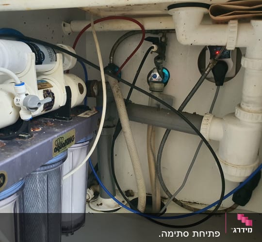 מערכת סינון מים עם צינורות וחיבורים מתחת לכיור